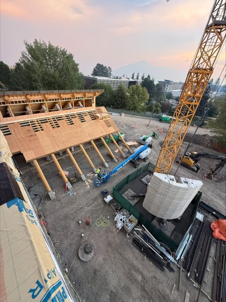 Elevated construction view of the Indigenous Centre, crane and surrounding work site.